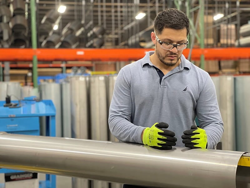 A Nordfab employee inspects the quality of the seam weld on a pipe